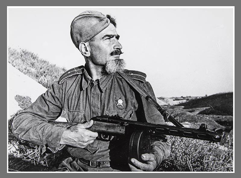 Bearded soldier and machine gun