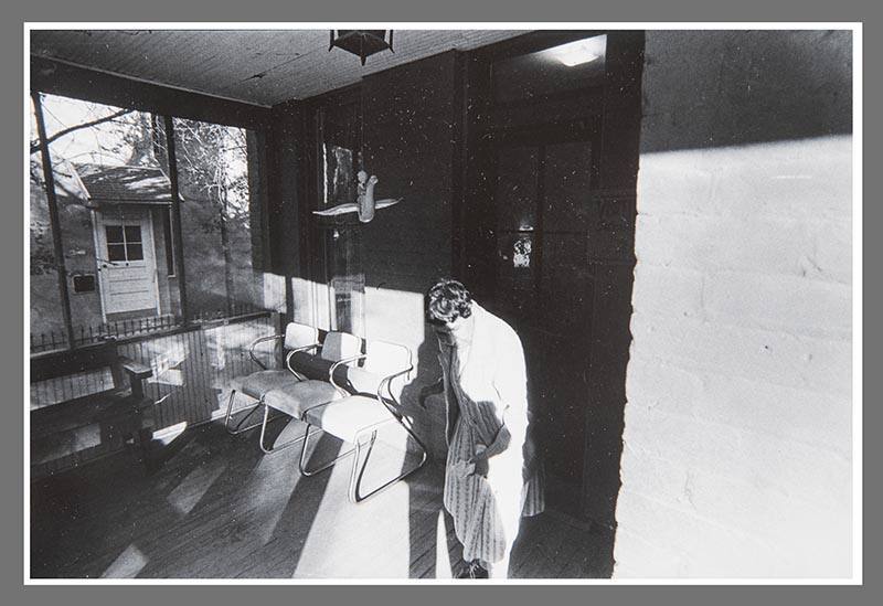 Untitled (Woman and chairs on front porch)