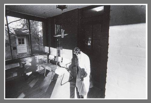 Untitled (Woman and chairs on front porch)