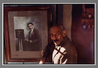 Untitled (Man with framed photograph of photographer with camera)